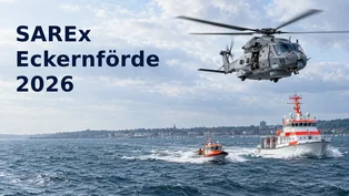Redaktionelle Illustration: Ein grauer Marinehubschrauber fliegt bei einer Such- und Rettungsübung über einem Seenotrettungskreuzer und einem Rettungsboot in der Eckernförder Bucht.