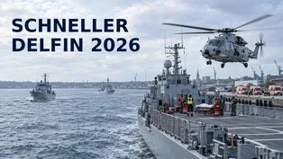Ein NH90 Sea Lion schwebt neben einem Minenjagdboot, auf dessen Flugdeck Rettungskräfte einen Übungsverletzten auf einer Trage versorgen; am Kieler Hafen warten Rettungswagen.